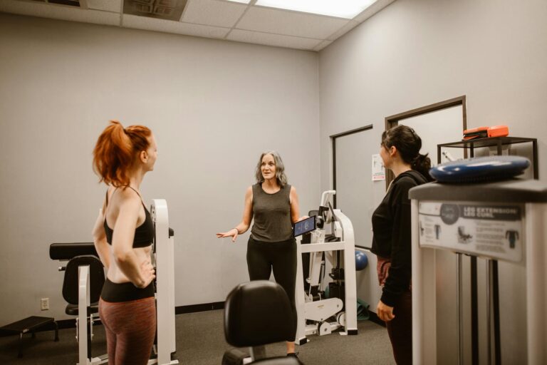 Three women discuss fitness and wellness in a gym setting, promoting healthy living.